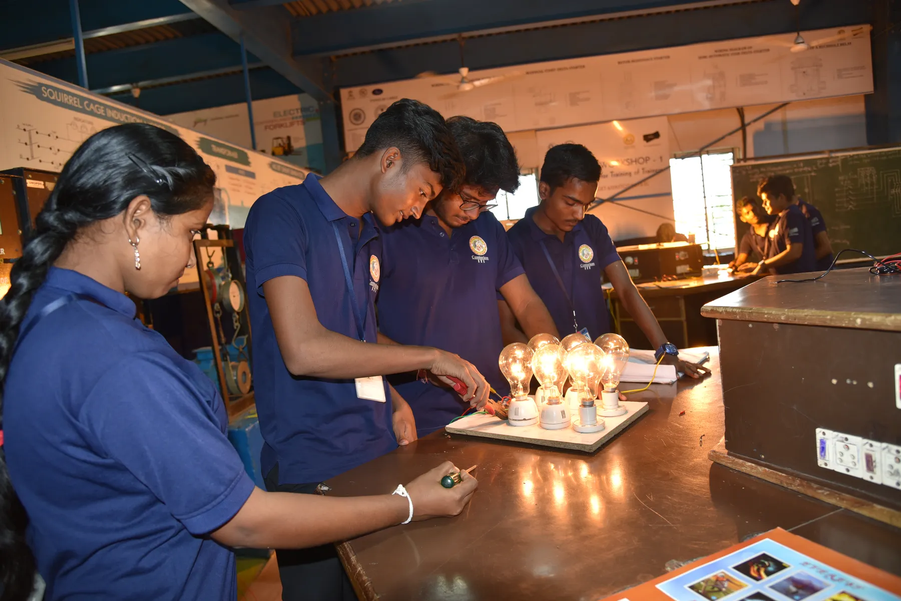 Trainees in Centurion ITI uniforms working on a live electrical circuit