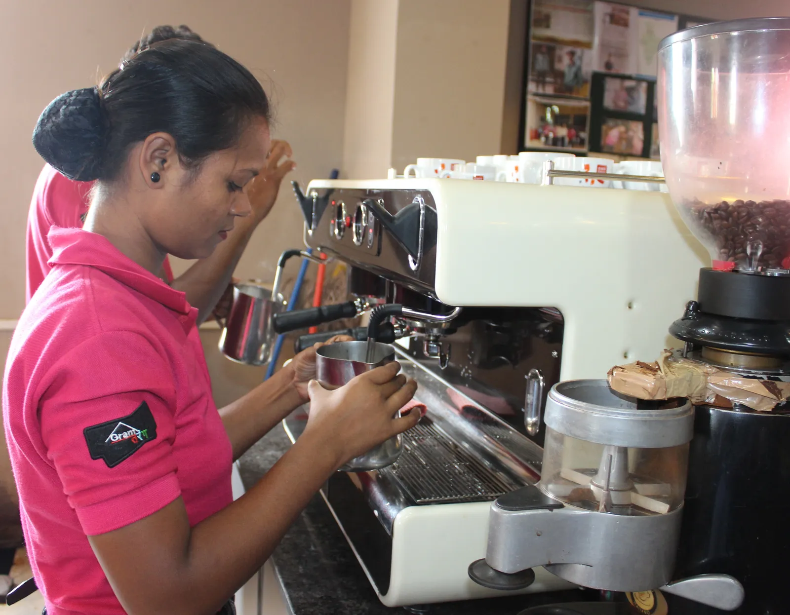 A brewmaster trainee steaming milk at a café training bar
